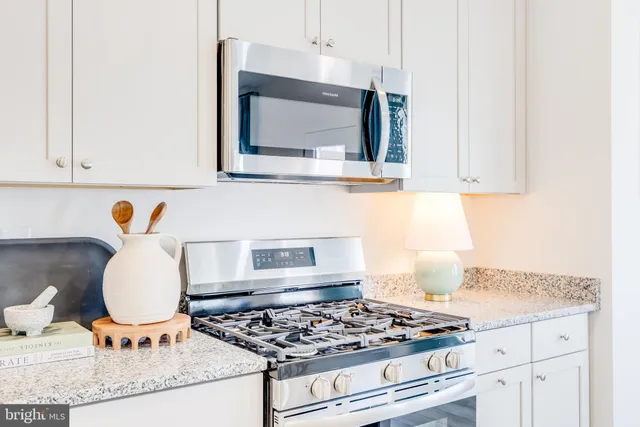 a kitchen with stainless steel appliances granite countertop a stove a sink and a microwave