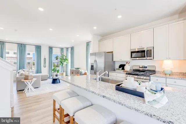 a living room with furniture a large window and a wooden floor
