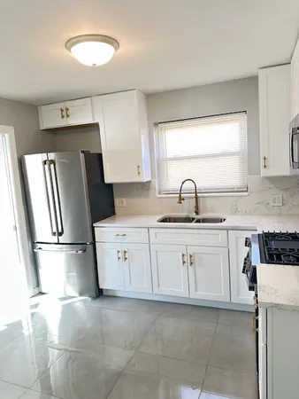 a kitchen with a sink a refrigerator and cabinets