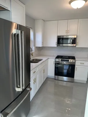 a kitchen with stainless steel appliances white cabinets and a refrigerator