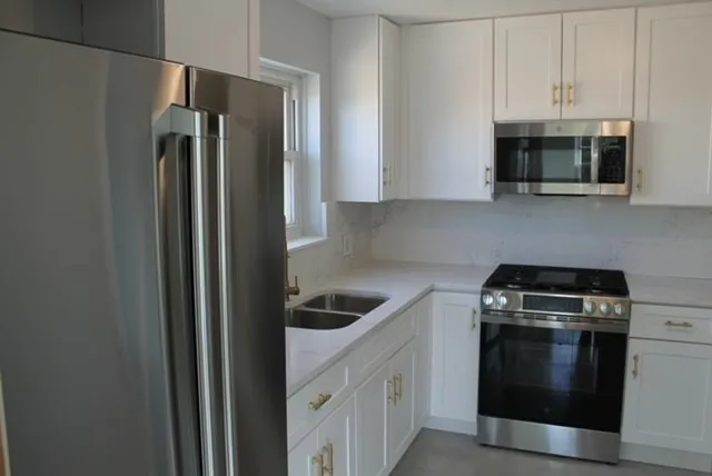 a kitchen with white cabinets and stainless steel appliances