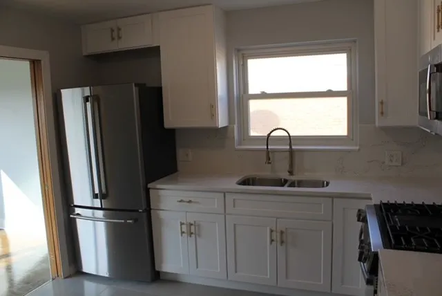 a kitchen with appliances a sink and a window