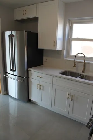 a kitchen with a refrigerator sink and cabinets