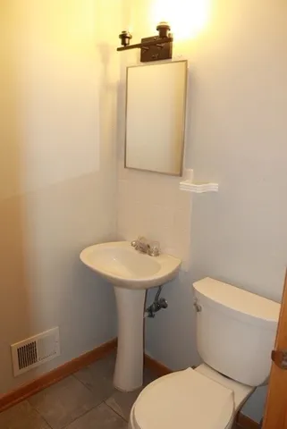 a white toilet sitting next to a bathroom sink