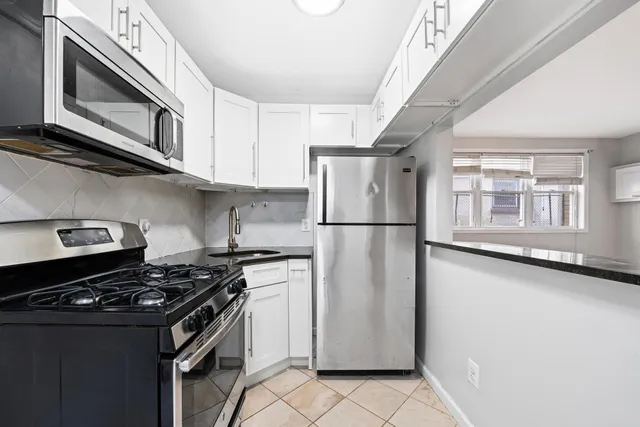 a kitchen with stainless steel appliances granite countertop a stove and a refrigerator