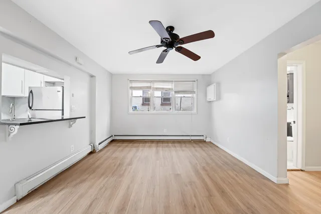 a view of empty room with wooden floor and window