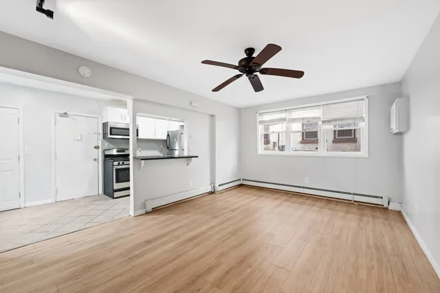 a view of a kitchen with wooden floor and stainless steel appliances