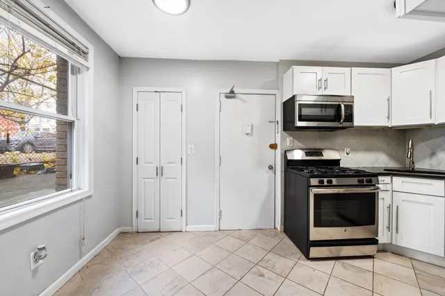 a kitchen with stainless steel appliances granite countertop a stove a microwave and a refrigerator