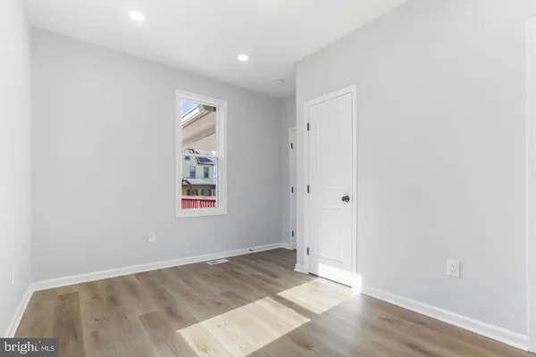 a view of a hallway with wooden floor and entryway