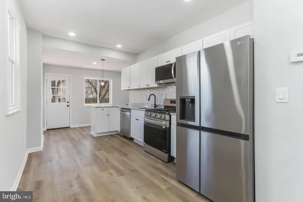 a kitchen with stainless steel appliances granite countertop a refrigerator microwave and sink
