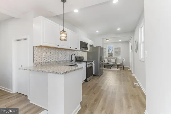 a kitchen with stainless steel appliances granite countertop a sink refrigerator and cabinets