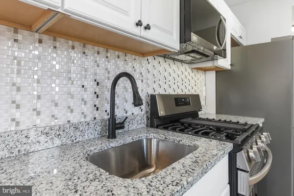 a kitchen with a sink a stove and a microwave