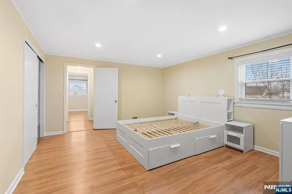 a living room with hard wood floors and kitchen view