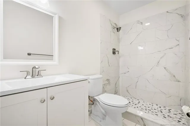 a bathroom with a sink toilet vanity and shower