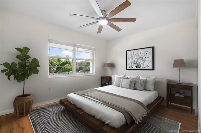 a bedroom with a large bed and a potted plant