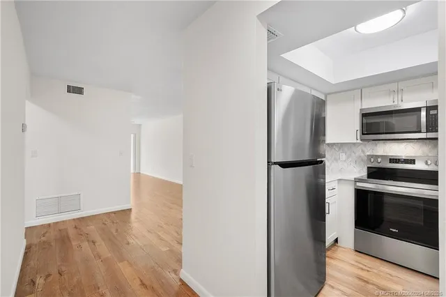 a kitchen with a refrigerator and a stove top oven