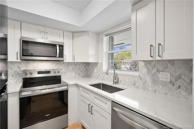 a kitchen with a sink stove and microwave
