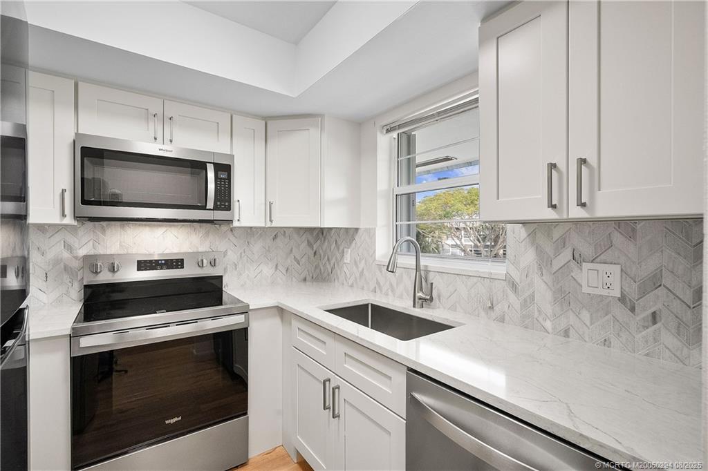 2929 Southeast Ocean Boulevard, Unit 1087 Stuart, FL 34996 - Photo 4 of 21 a kitchen with a sink stove and microwave