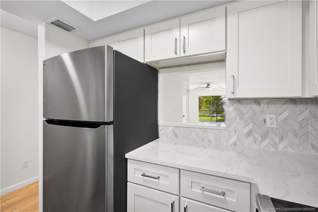 2929 Southeast Ocean Boulevard, Unit 1087 Stuart, FL 34996 - Photo 5 of 21 a white refrigerator freezer sitting in a kitchen