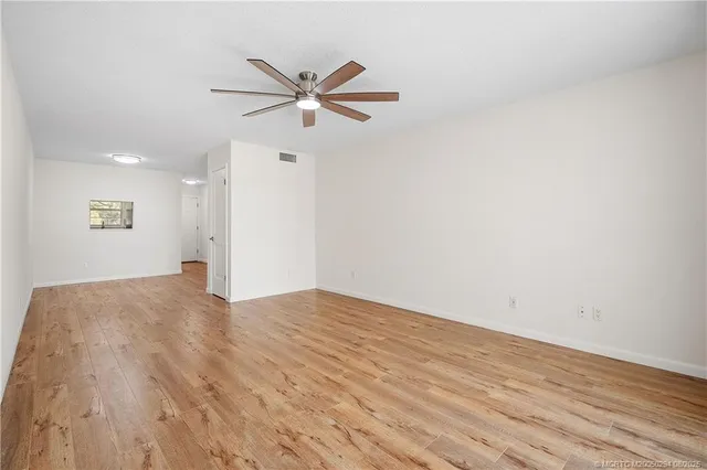 a view of a big room with wooden floor and windows