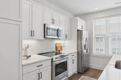 a kitchen with stainless steel appliances granite countertop a sink a stove and a refrigerator