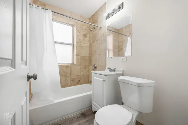 a white toilet sitting next to a bath tub