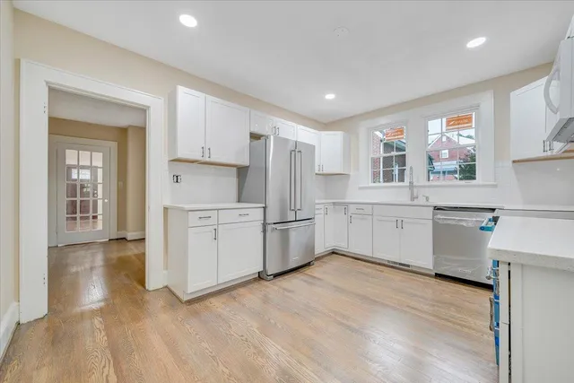 a kitchen with white cabinets and white appliances