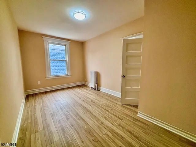 a view of a livingroom with wooden floor and a window