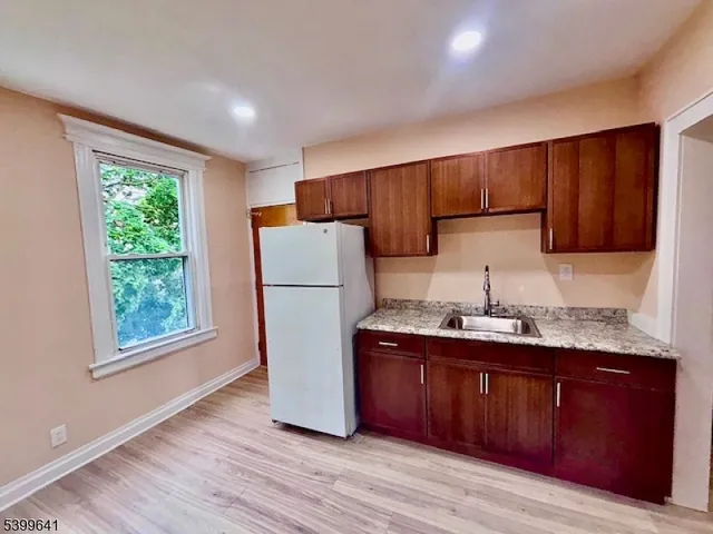 a kitchen with a sink a stove a refrigerator and cabinets