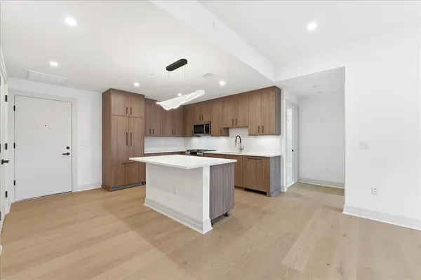 a kitchen with kitchen island a sink stainless steel appliances and cabinets
