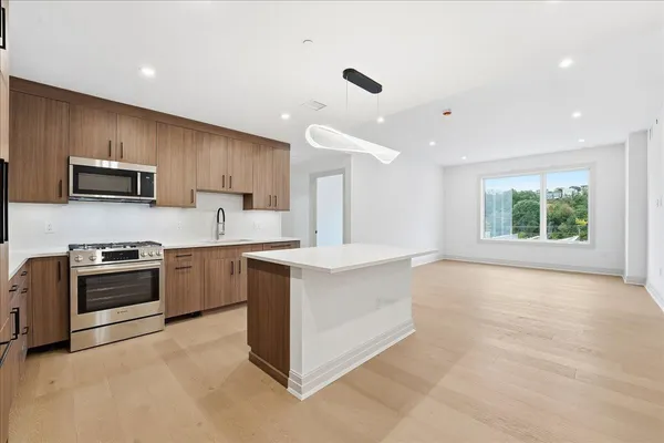 a view of an empty room with a kitchen