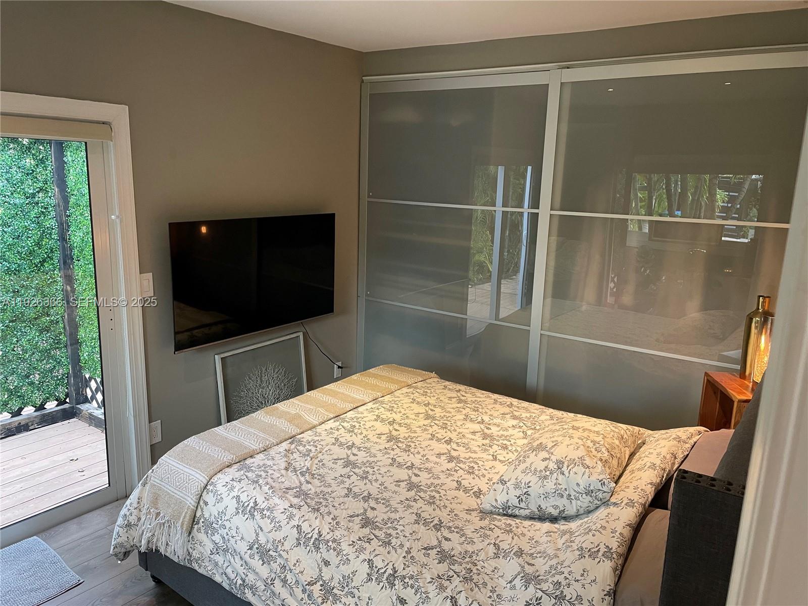 2654 Southwest 25th Terrace Miami, FL 33133 - Photo 15 of 36 a bedroom with a bed and a flat screen tv