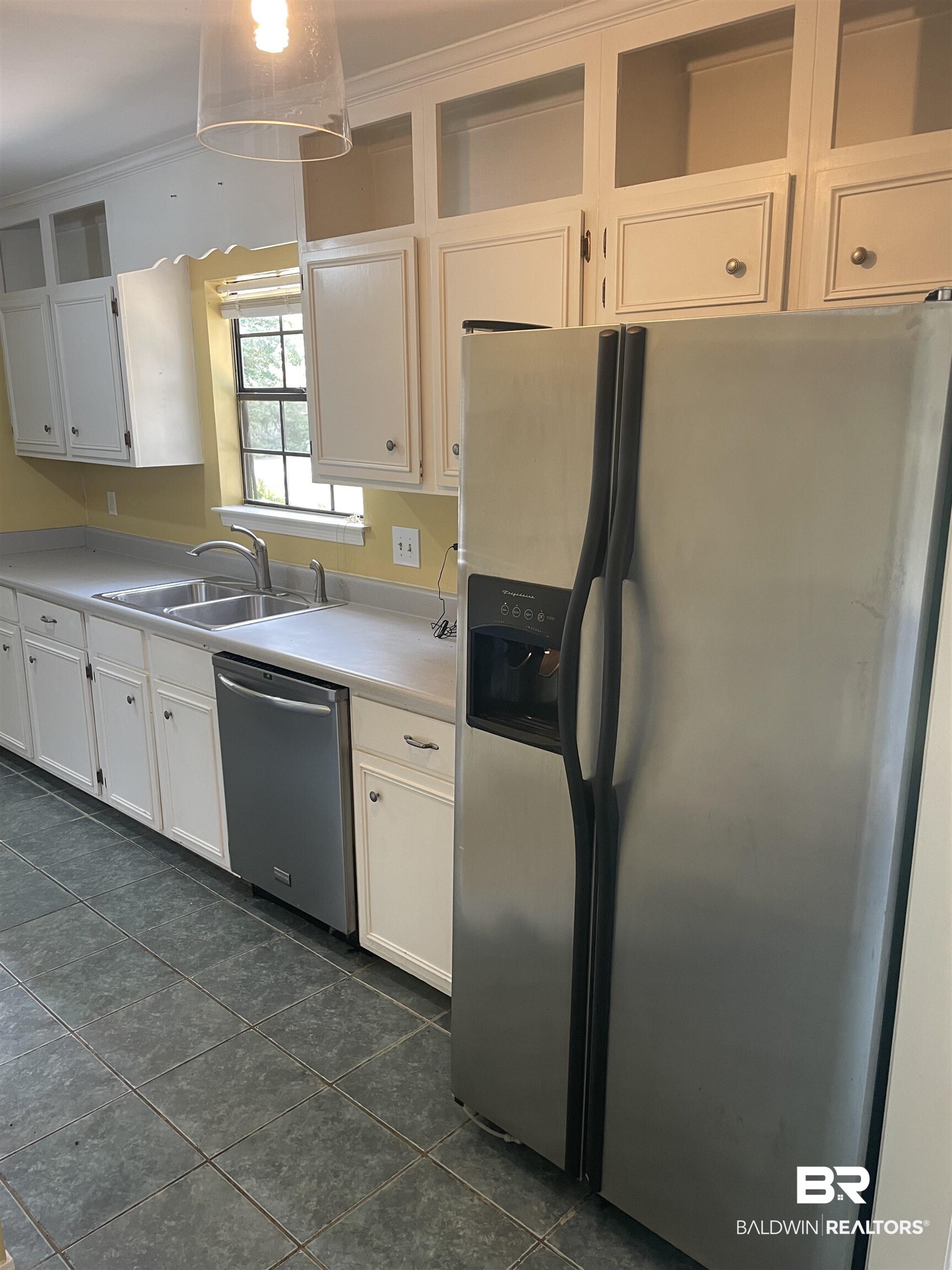 115 Leigh Circle Daphne, AL 36526 - Photo 10 of 12 Kitchen with stainless steel appliances, sink, dark tile patterned floors, and white cabinetry