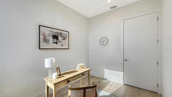 a view of a workspace with furniture and wooden floor