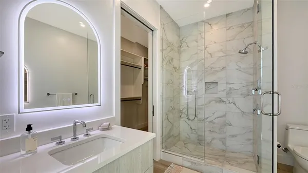a bathroom with a sink shower and a mirror