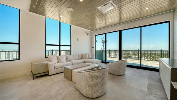 a living room with furniture and a floor to ceiling window