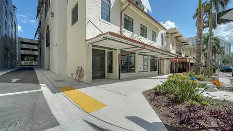 a view of a white house with many windows and yard