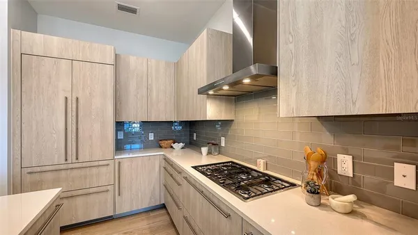 a kitchen with stainless steel appliances a stove a sink and a white cabinets
