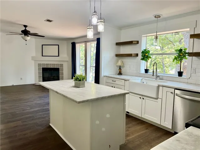 a kitchen with granite countertop a sink stove and refrigerator