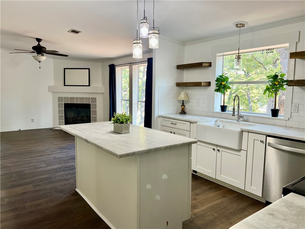 a kitchen with granite countertop a sink stove and refrigerator