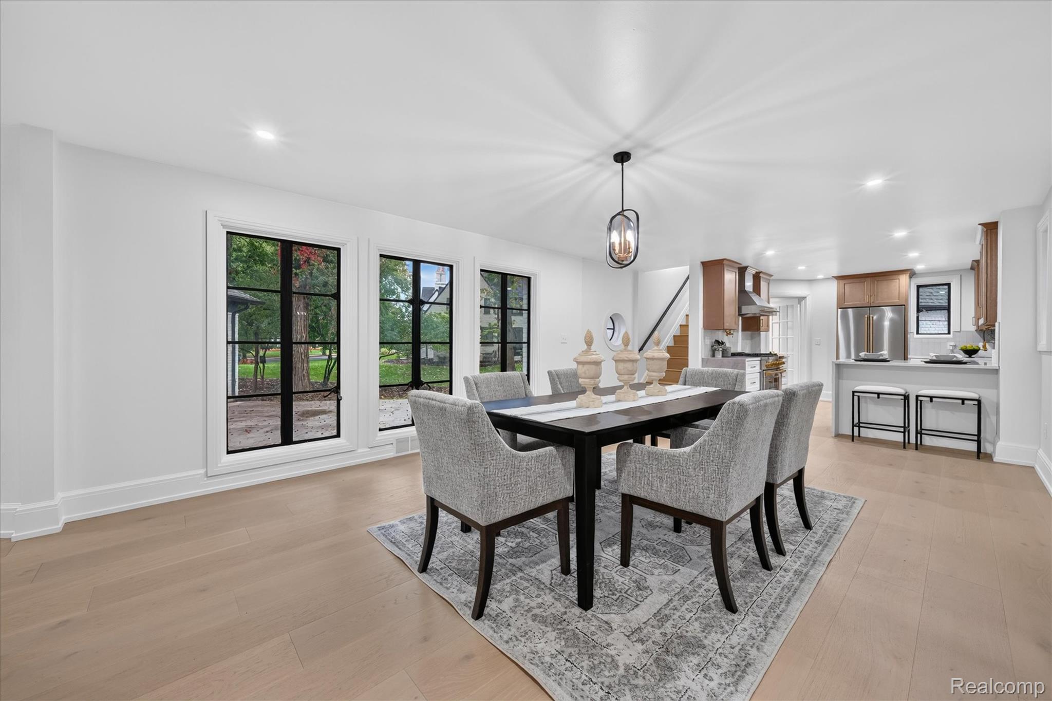 3250 Sherbourne Road Detroit, MI 48221 - Photo 12 of 36 Open-concept dining area featuring light wood-finish flooring, a contemporary chandelier, and large windows