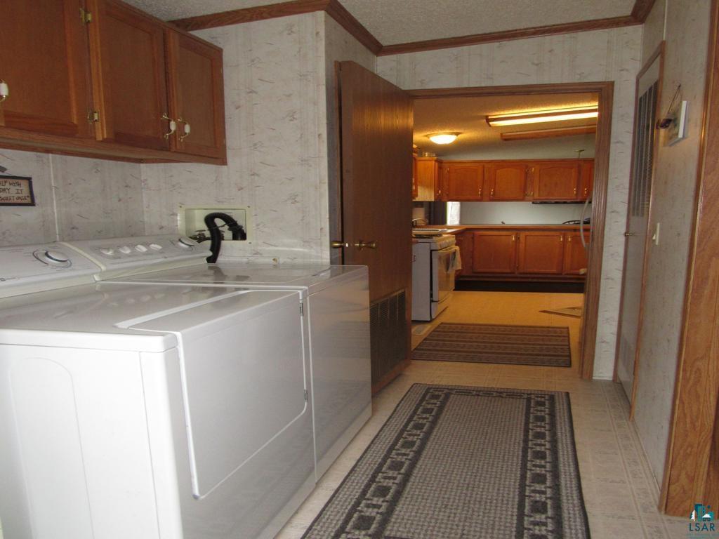 5243 East Neuman Road Superior, WI 54880 - Photo 29 of 35 Laundry area featuring crown molding, washing machine and dryer, and light tile floors