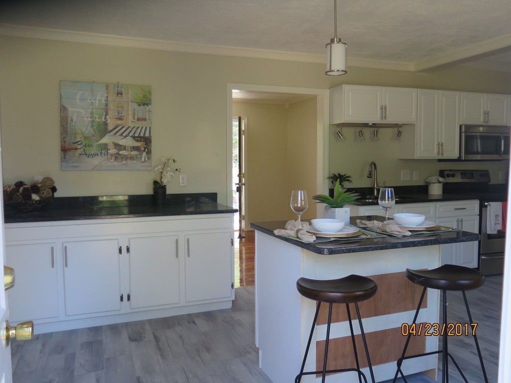 16 Mashapaug Road Sturbridge, MA 01566 - Photo 14 of 26 a kitchen with granite countertop white cabinets and chairs