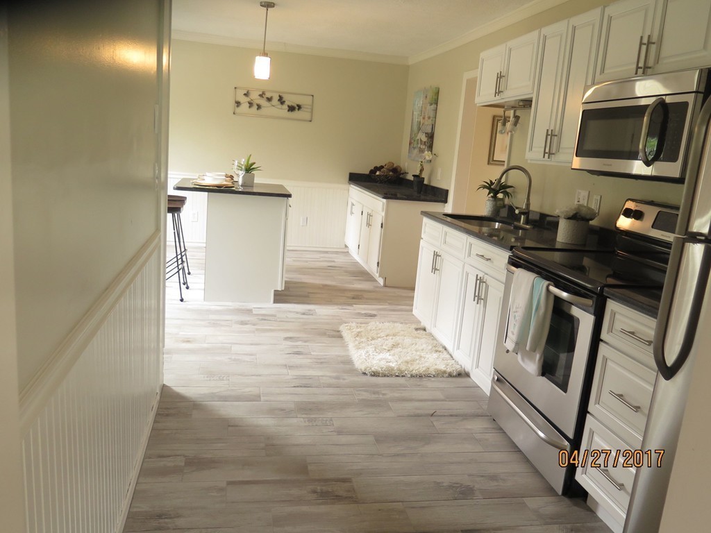16 Mashapaug Road Sturbridge, MA 01566 - Photo 20 of 26 a kitchen with granite countertop a stove a sink and a microwave