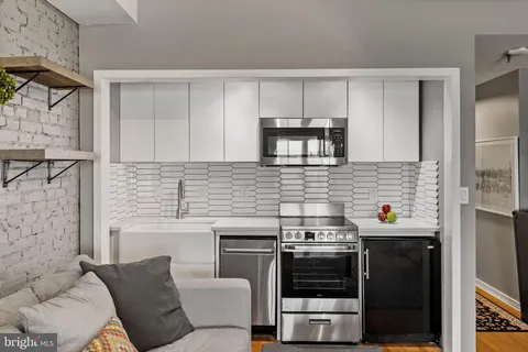 a kitchen with stainless steel appliances a stove a sink and a microwave