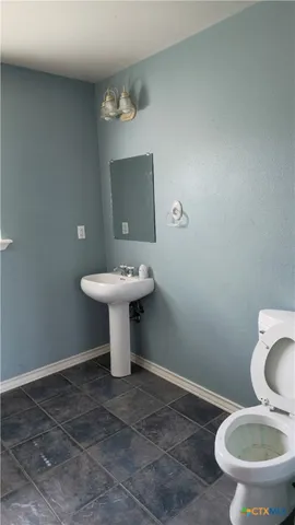 a bathroom with a sink toilet and a mirror