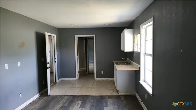 an empty room with a window and wooden floor