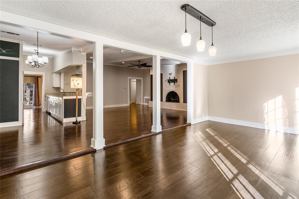203 Walnut Way Euless, TX 76039 - Photo 11 of 36 a view of a big room with wooden floor and a kitchen