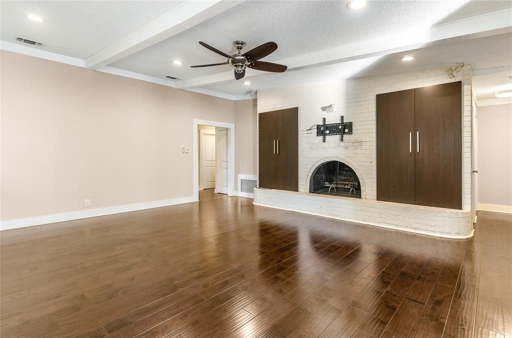 203 Walnut Way Euless, TX 76039 - Photo 9 of 36 a view of a livingroom with a fireplace a ceiling fan and wooden floor