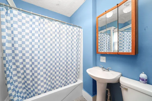 a bathroom with a sink toilet and mirror